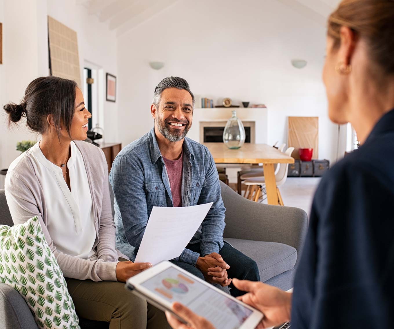 People discussing 15-year vs. 30-year fixed mortgage options with loan officer.