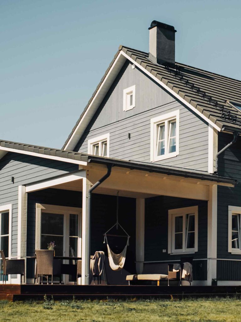 Outside of blue suburban home with back patio purchased with a cash offer.