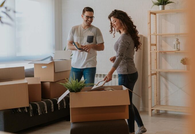 Couple unpacks boxes while moving into new home after closing on their house.