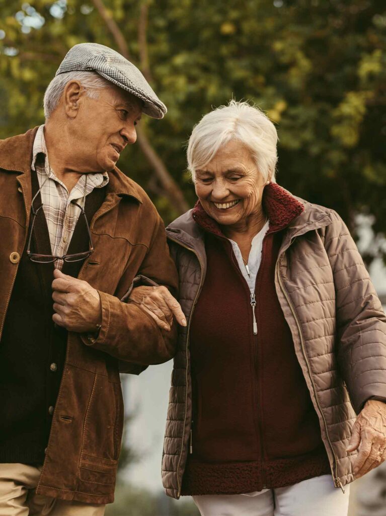 Elderly couple walking outside together discussing pros and cons of a bridge loan.
