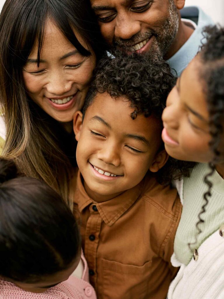 Family of five embracing in a hug.