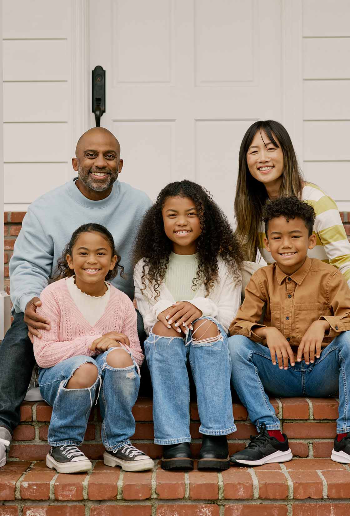 A family takes their first family photo on the porch of their new home thanks to CCM Smart Start.