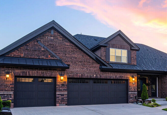 Red brick modern farmhouse with wraparound porch and gabled roof showcasing a timeless home style.