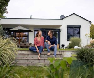 A couple sitting on their porch discussing when mortgage rates will go down & their mortgage refinance options.