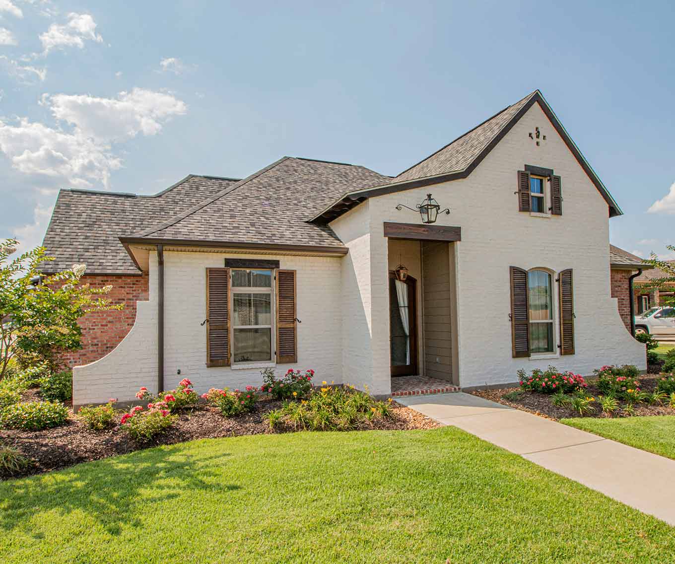 Exterior of cottage style home with whitewash brick style.